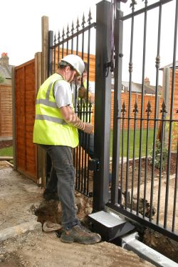 workman in high vis fixing electric gate