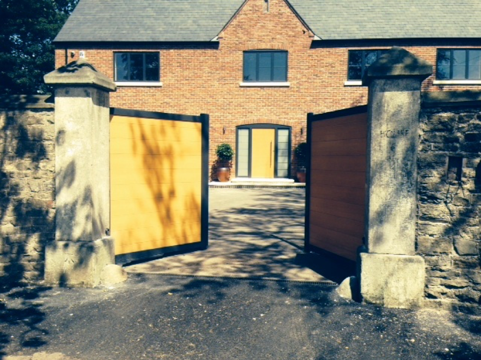 A picture of an automated open gate in front of a house